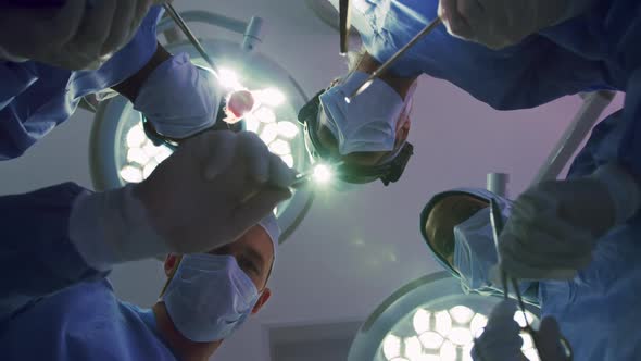 Upward view of Multi-ethnic Surgeons performing surgery in operation theater at hospital