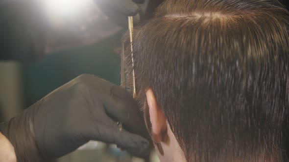 Barber Cutting Client's Hair on the Sides with a Scissors