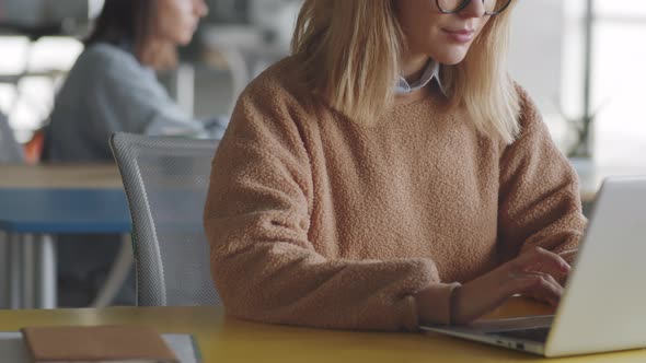 Blonde Businesswoman Working on Laptop at Desk