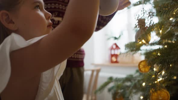 Little girl with daddy decorating the Christmas tree. Shot with RED helium camera in 8K