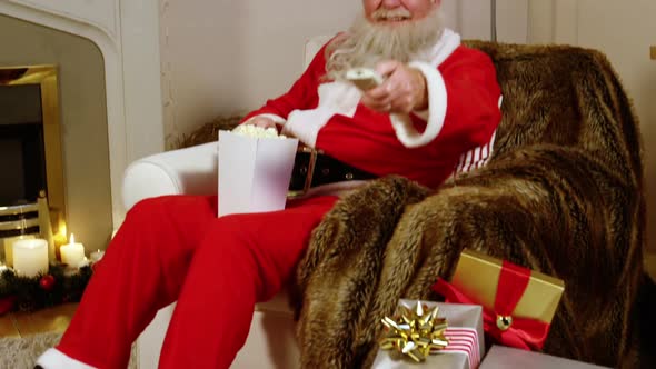 Santa claus eating popcorn while watching television