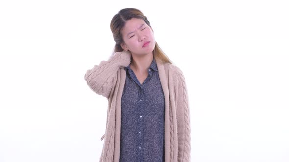 Stressed Young Asian Woman Having Neck Pain in Winter