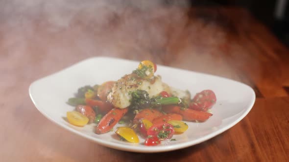 Smoking Delicious Halibut In A Plate Served With Vegetables. close up