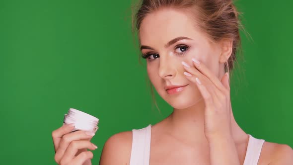 Pretty Girl Applying Facial Cream on Green Chromakey