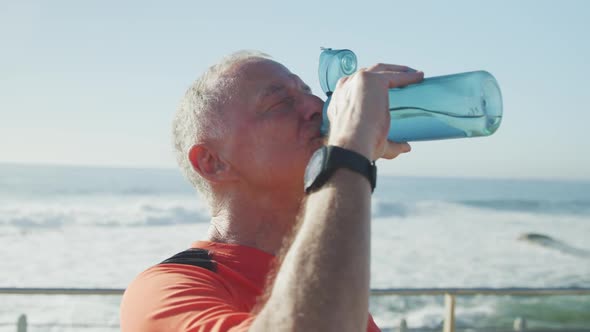 Senior man drinking water on the promenade