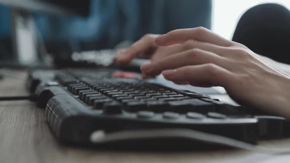 View of Female Hands Typing Fast on Keyboard on Blurred Background