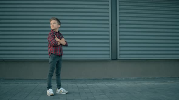 Cute Stylish Model Boy Is Posing. Fashion Serious Child Boy Is Looking To the Camera at Modern Blue