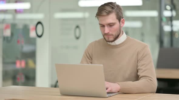 Creative Young Man Working on Laptop in Office