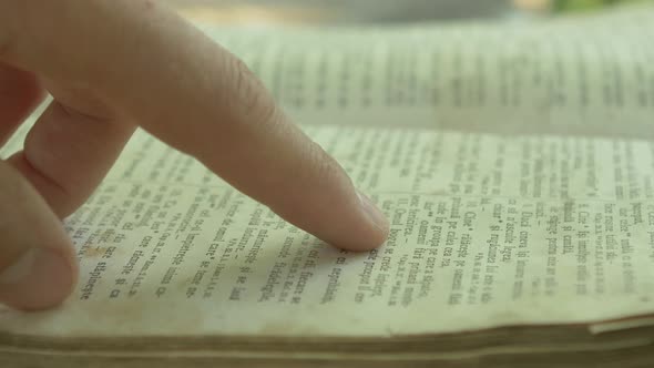 Close up view of a hand browsing the Bible