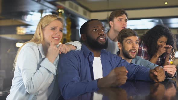 Multiracial Friends Watching Sports in Bar, Upset About Losing Game, Defeat