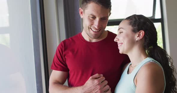 Happy caucasian couple talking and looking out the window