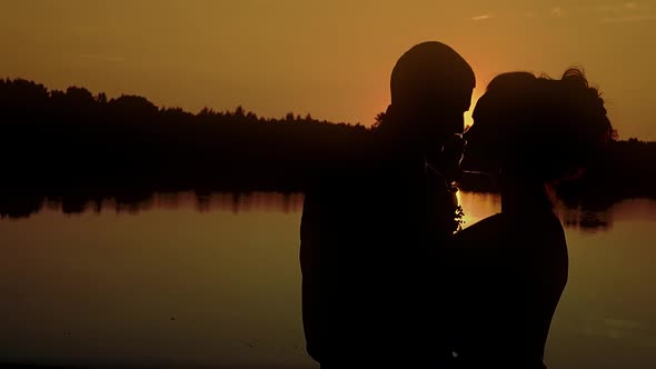 Two Young People Hugging Against the Backdrop of a Sunset By the River Closeup Slow Motion