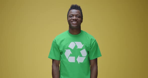 Man Standing Firm While Wearing t Shirt with Recycling Symbol