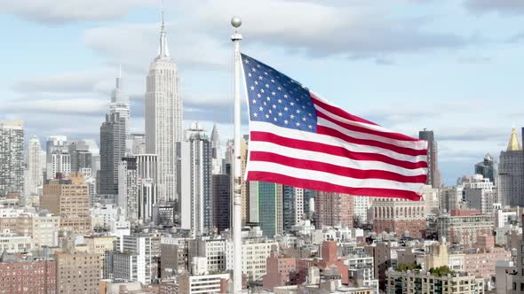 Aerial cinematic shoot of USA flag waiving in the wind with Empire State Building in the background.