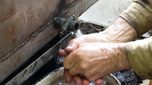 Man is washing his hands with rainwater