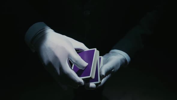 Closeup of a Suited Magician's Hands Performing Sleight of Hand Card Tricks