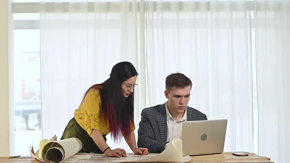 man and a woman make adjustments and edits to the project on a laptop.