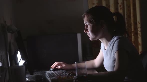 Young Woman Playing Computer Games with Chips and Drinks