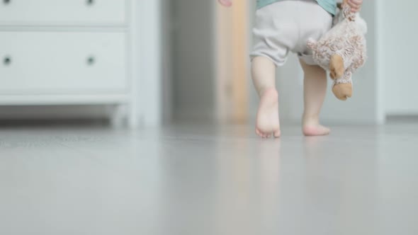 First Steps Closeup View Toddler Baby Legs and Feet Barefoot Walking on Floor