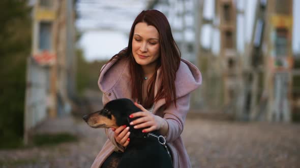 Pretty Woman Plays with Her Beagle Dog at Old Abandoned Bridge