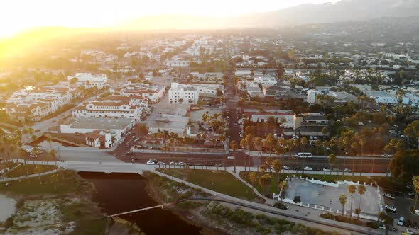 Aerial drone shot rising up over the beach with palm trees and beautiful city buildings and homes of