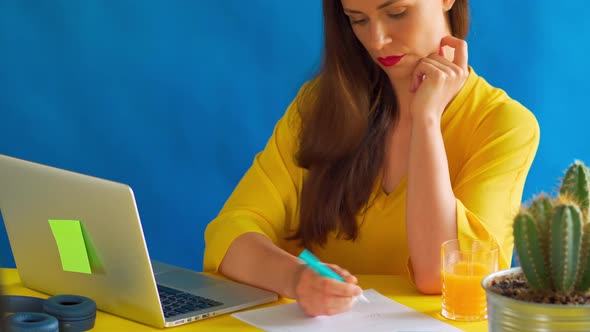 Woman in a Yellow Blouse Works Remotely at Home During a Pandemic