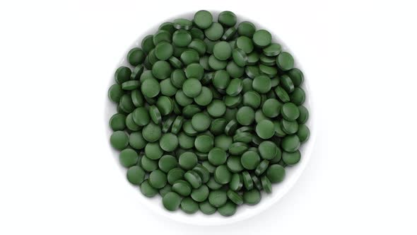 superfoods Spirulina, chlorella supplement green pills top view rotation