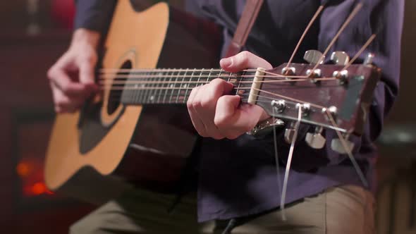 Male Hands Playing a Song on an Acoustic Guitar