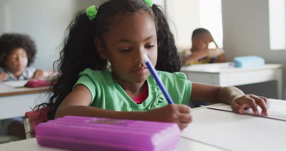Video of focused african american girl doing lessons in classroom