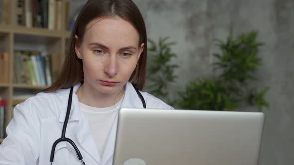 Woman Doctor Using on Her Laptop Computer in Medical Office