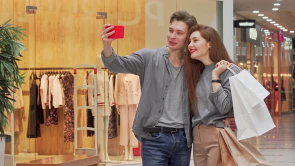 Lovely Young Couple Taking Selfies While Shopping at the Mall Together