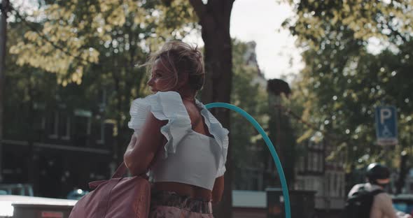 Woman walks with Hula Hoop and  bag