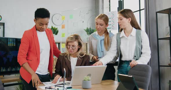 Businesswomen Working with Financial Papers while Brainstorming Over Joint Computer Project