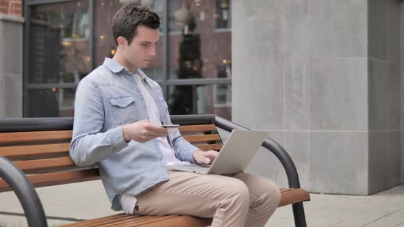 Online Shopping By Young Man Sitting on Bench