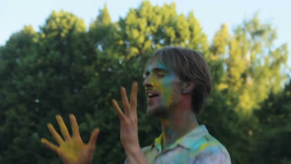 Young Man Covered in Colored Paint Dancing and Having Fun at Holi Festival