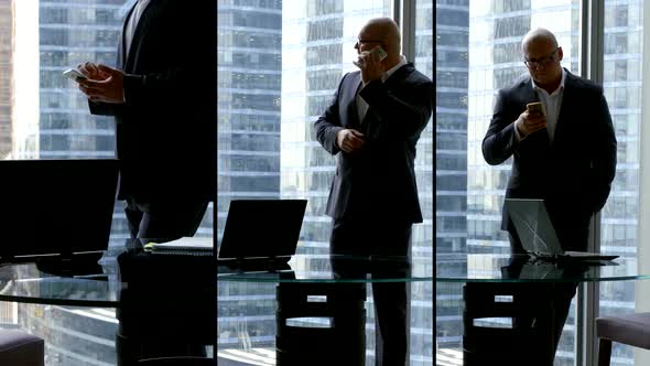 Successful Businessman is Working in His Office in Modern Skyscraper Calling By Cell Phone