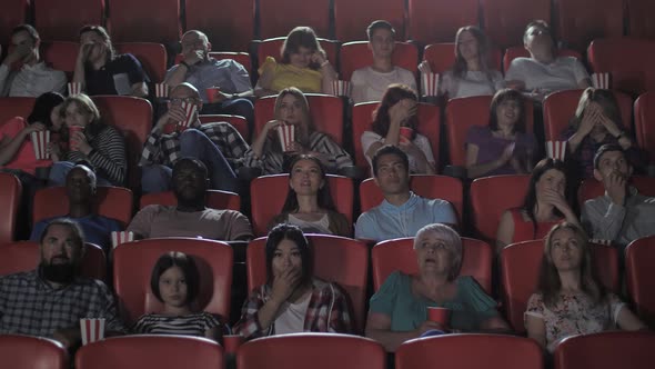 Diverse Moviegoers Watching Horror in Cinema Hall