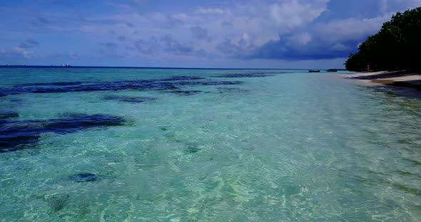 Beautiful flying tourism shot of a sunshine white sandy paradise beach and aqua blue water backgroun