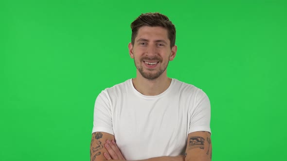 Portrait of Confident Guy Is Looking Straight, Crossing His Arms Over His Chest and Nodding His Head