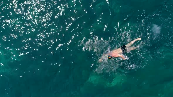 Aerial view of man swimming in the sea of Kioni island, Greece