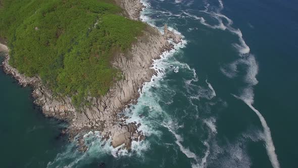 View From a Drone Vertically Down on a Stone Cape Washed By Strong Waves