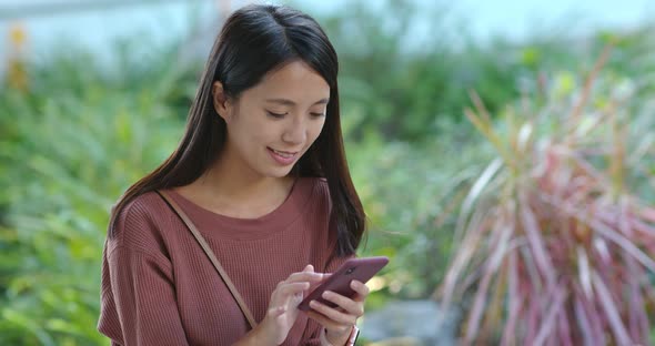 Woman look at mobile phone in the park