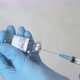Doctor draws coronavirus vaccine into a syringe. - VideoHive Item for Sale