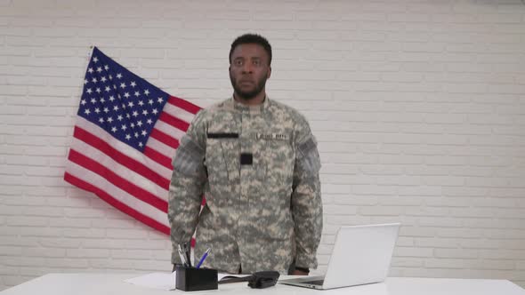 Afro-american Male Soldier in Camouflage Sitting in Office