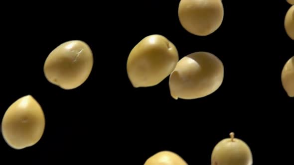 Closeup of the Big Green Olives Flying Diagonally on the Black Background