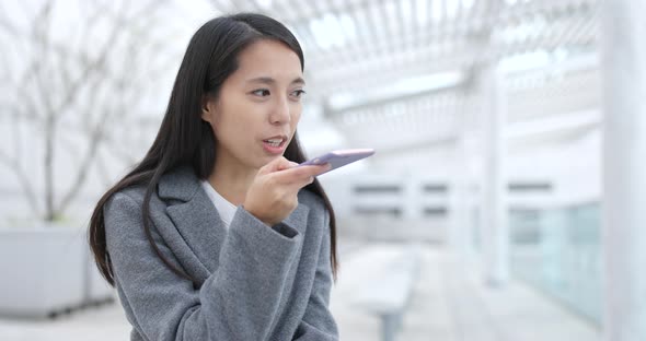 Businesswoman sending audio message on cellphone