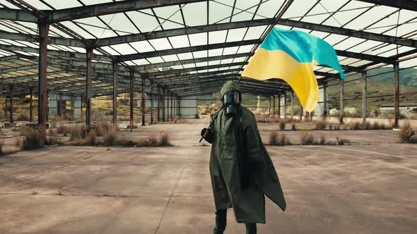 Soldier Man with Gas Mask Waves Ukrainian Flag in a War Warehouse