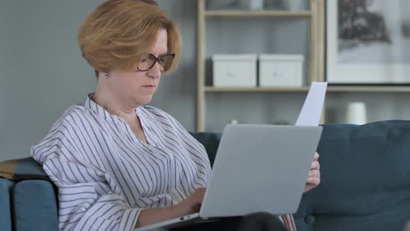 Penisve Old Senior Woman Doing Paperwork and Using Laptop