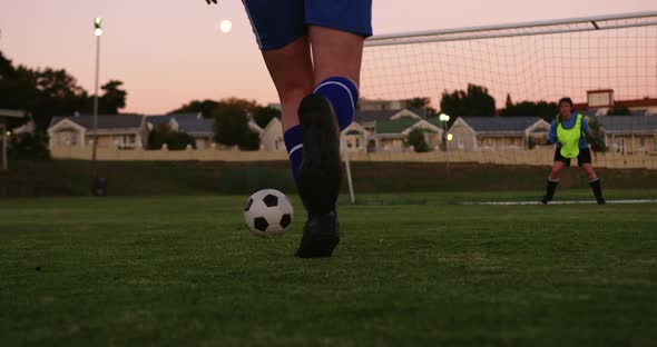 Female soccer player scoring goal while keeper tries to catch it on soccer field. 4k