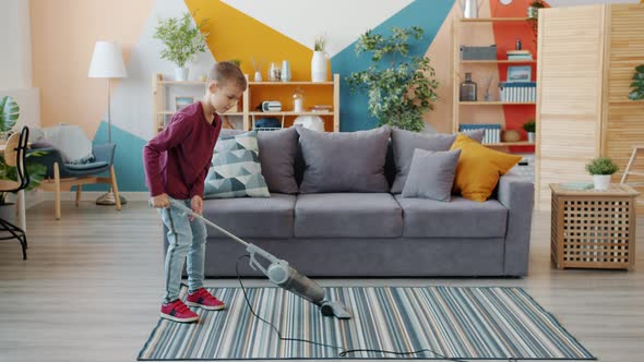 Slow Motion of Helpful Boy Vacuuming Floor at Home Using Vacuum Cleaner Doing Housework